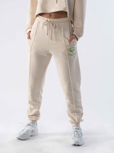 Model is wearing joggers in the colour eggnog.