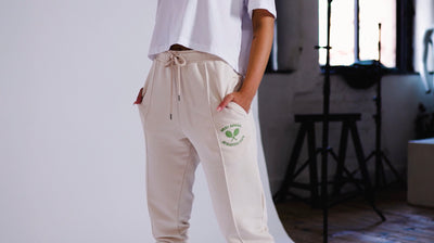 model wearing relaxed joggers in eggnog with tennis embroidery to the thigh. modelling in manchester, united kingdom