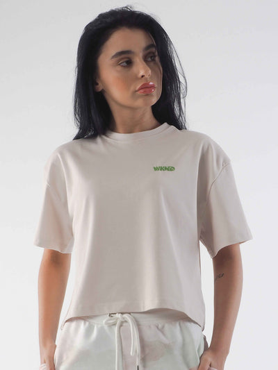 Model has dark hair and is wearing a baggy oversized tee in soft beige.