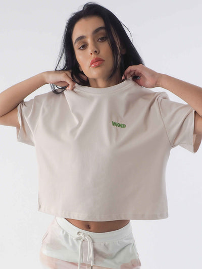 Model is wearing the WKND Apparel cropped tee in soft beige.