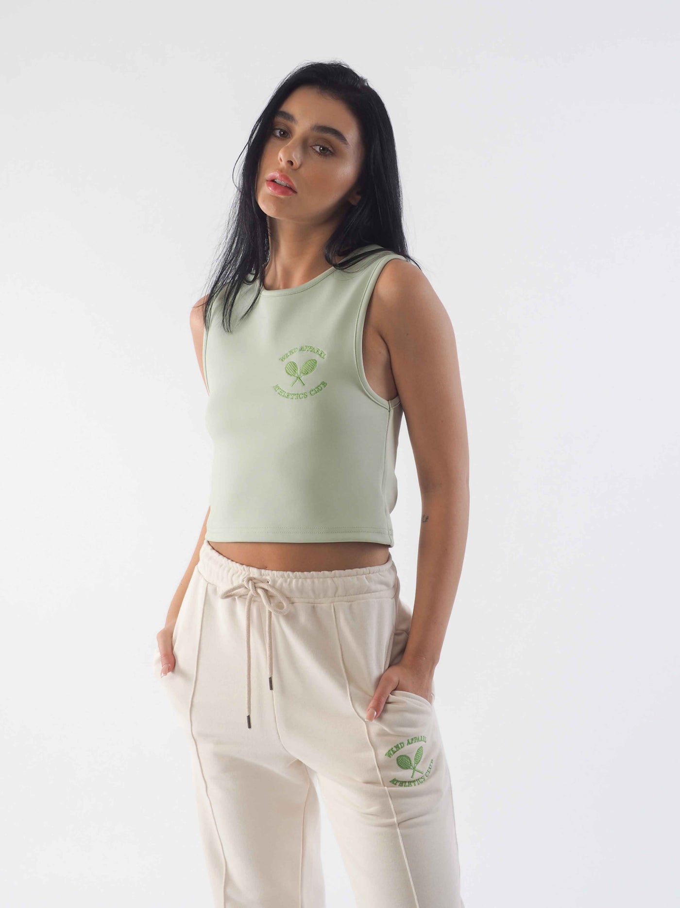 Model with dark hair wearing the jade green vest and eggnog joggers.