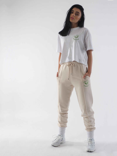 Model is wearing joggers in the colour eggnog and a white cropped t-shirt. Both have green WKND Apparel embroidery.