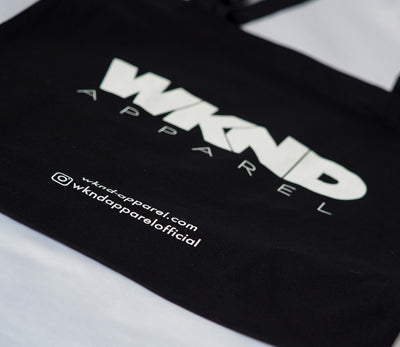 black cotton tote bag with long handles featuring the wknd apparel brand logo