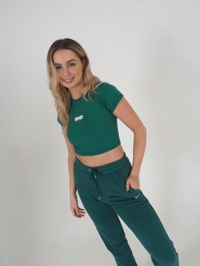 Blonde model wearing a green cropped t-shirt and matching joggers.  The contrast WKND logo is printed centrally on the chest.
