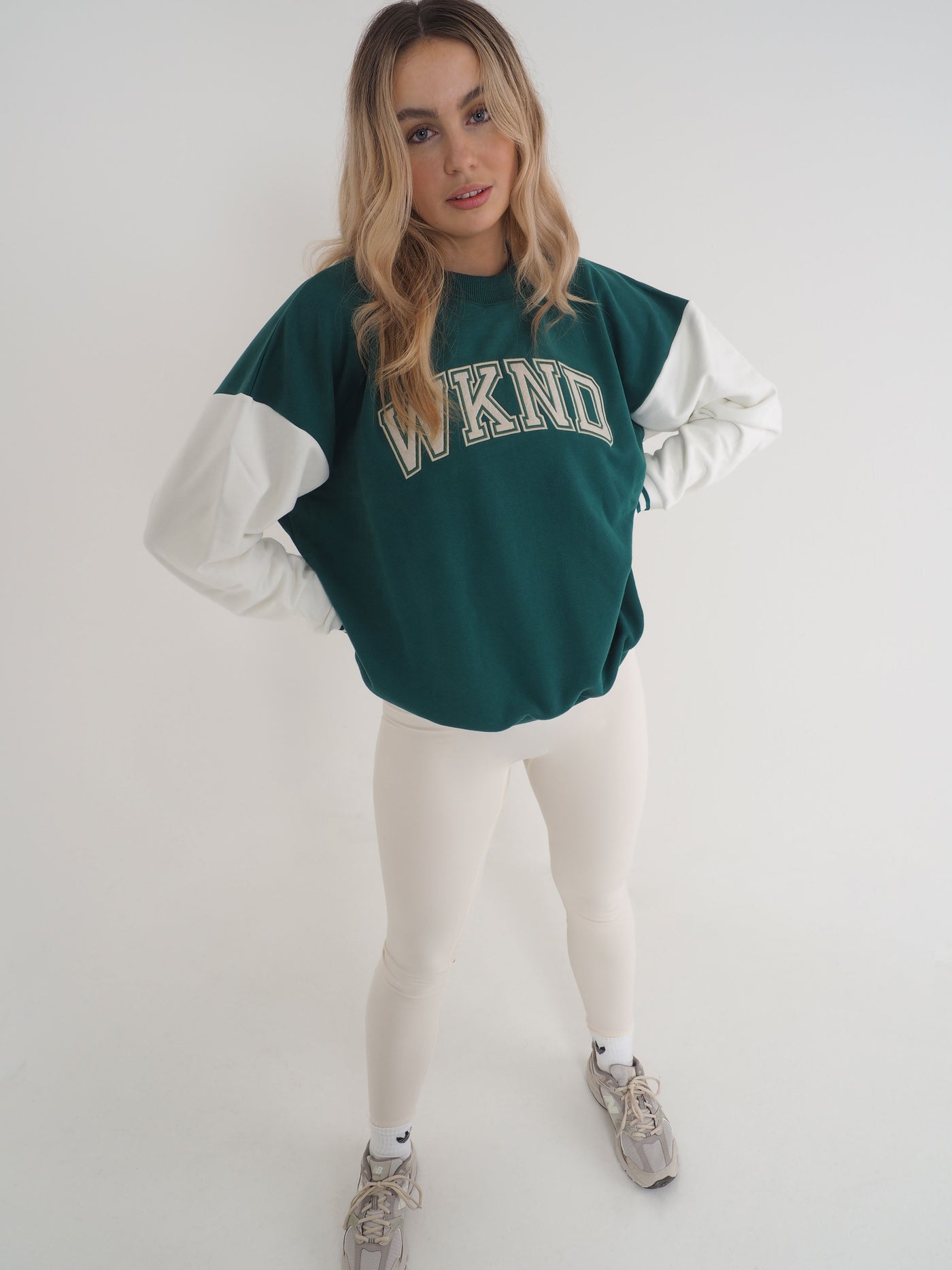 Blonde model is wearing a college varsity sweatshirt with eggnog leggings.  The WKND logo sewn to the chest.